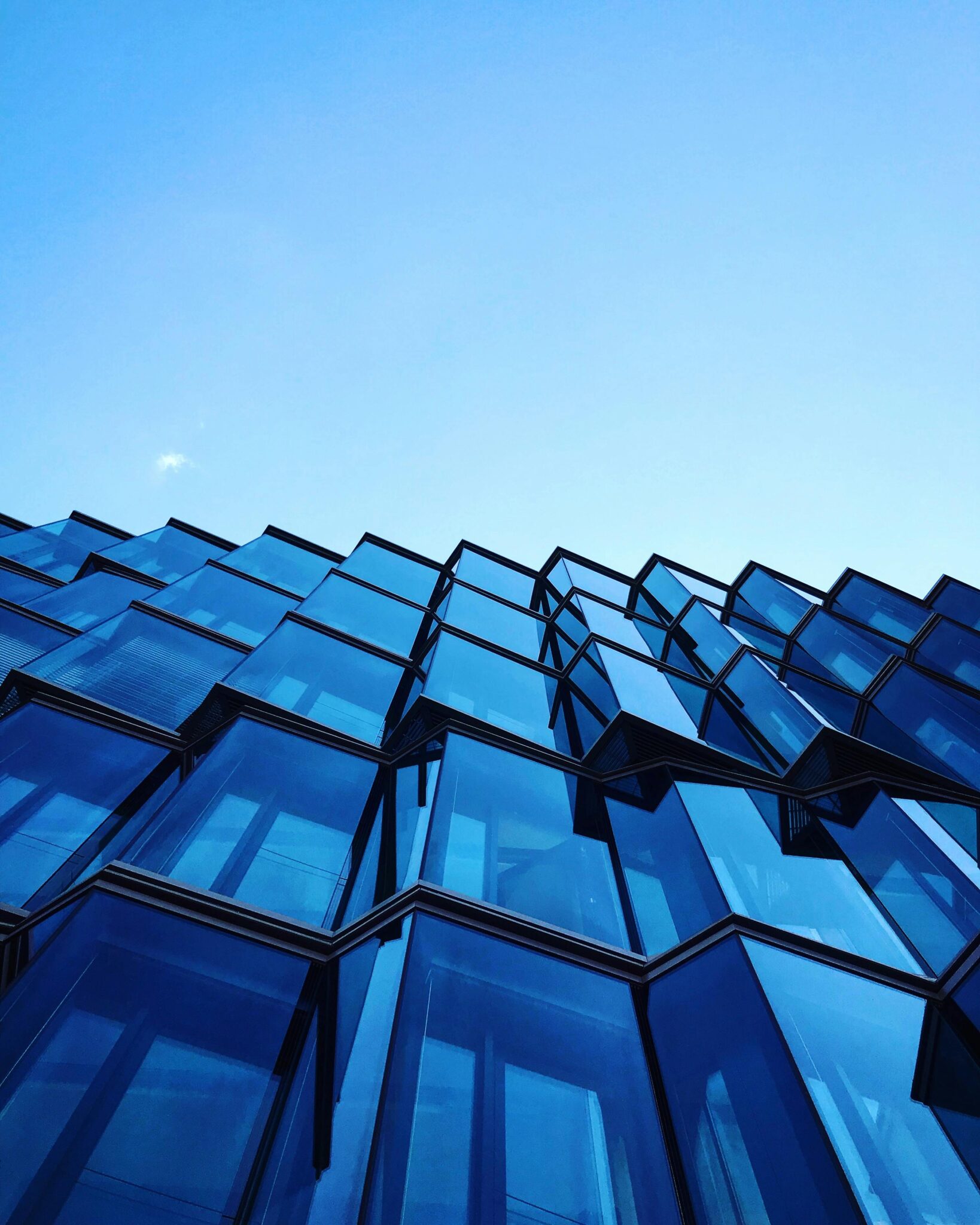 Dynamic modern architecture with striking blue glass facade in Berlin.