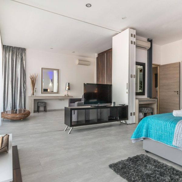 Spacious and modern bedroom with sleek design, featuring elegant decor and natural lighting.